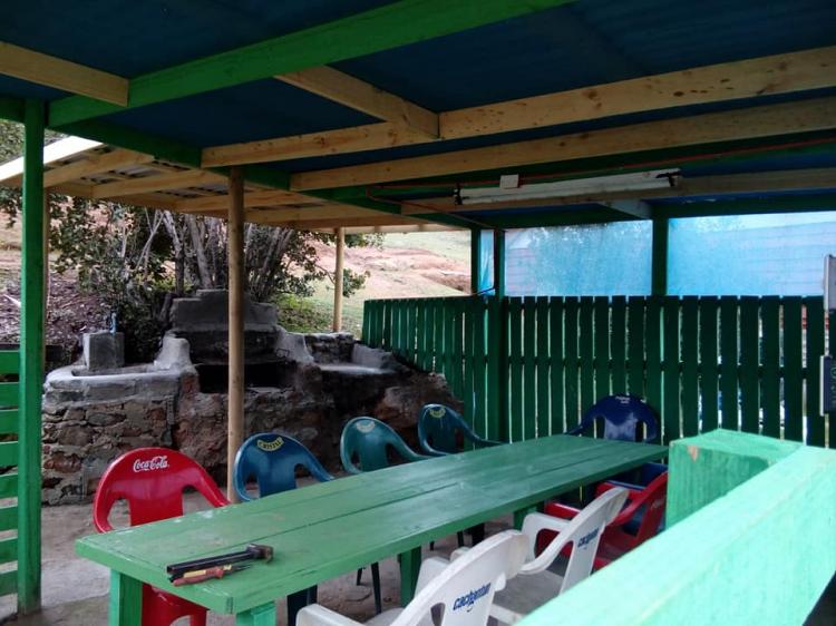 Sector cubierto con parrillas, mesa y asientos